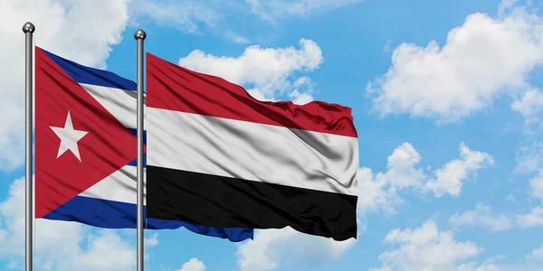 Kuba- und Jemen-Flagge wehen gemeinsam im Wind vor dem wolkenverhangenen blauen Himmel. Diplomatie-Konzept, internationale Beziehungen. — Stockfoto