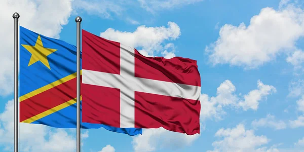 Konžská a Dánská vlajka mávajících větrem proti bíle zatažené modré obloze. Diplomacie, mezinárodní vztahy. — Stock fotografie