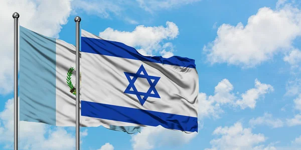 Bandera de Guatemala e Israel ondeando en el viento contra el cielo azul nublado blanco juntos. Concepto diplomático, relaciones internacionales . — Foto de Stock