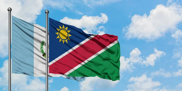 Guatemala en Namibië vlag zwaaien in de wind tegen witte bewolkte blauwe hemel samen. Diplomatie concept, internationale betrekkingen. — Stockfoto