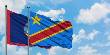 Guam ve Kongo bayrağı birlikte beyaz bulutlu mavi gökyüzüne karşı rüzgarda sallayarak. Diplomasi kavramı, uluslararası ilişkiler.