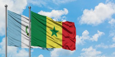 Guatemala ve Senegal bayrağı birlikte beyaz bulutlu mavi gökyüzüne karşı rüzgarsal sallayarak. Diplomasi kavramı, uluslararası ilişkiler.