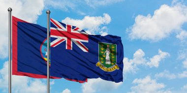 Guam ve İngiliz Virgin Adaları bayrağı birlikte beyaz bulutlu mavi gökyüzüne karşı rüzgarda sallayarak. Diplomasi kavramı, uluslararası ilişkiler.