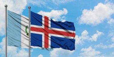 Guatemala ve İzlanda bayrağı birlikte beyaz bulutlu mavi gökyüzüne karşı rüzgarsal sallayarak. Diplomasi kavramı, uluslararası ilişkiler.