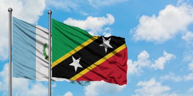 Guatemala ve Saint Kitts ve Nevis bayrağı birlikte beyaz bulutlu mavi gökyüzüne karşı rüzgarda sallayarak. Diplomasi kavramı, uluslararası ilişkiler.
