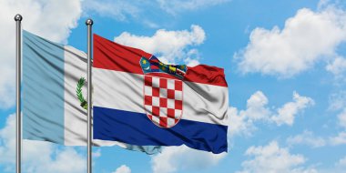 Guatemala ve Hırvatistan bayrağı birlikte beyaz bulutlu mavi gökyüzüne karşı rüzgarda sallayarak. Diplomasi kavramı, uluslararası ilişkiler.