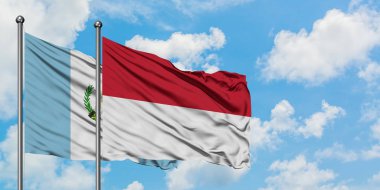 Guatemala ve Endonezya bayrağı birlikte beyaz bulutlu mavi gökyüzüne karşı rüzgarsal sallayarak. Diplomasi kavramı, uluslararası ilişkiler.