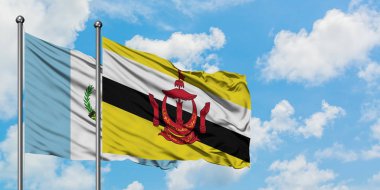 Guatemala ve Brunei bayrağı birlikte beyaz bulutlu mavi gökyüzüne karşı rüzgarda sallayarak. Diplomasi kavramı, uluslararası ilişkiler.