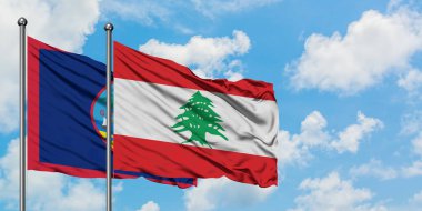 Guam ve Lübnan bayrağı birlikte beyaz bulutlu mavi gökyüzüne karşı rüzgarda sallayarak. Diplomasi kavramı, uluslararası ilişkiler.