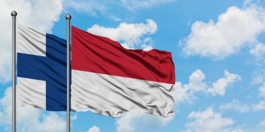 Finlandiya ve Monako bayrağı birlikte beyaz bulutlu mavi gökyüzüne karşı rüzgarsal sallayarak. Diplomasi kavramı, uluslararası ilişkiler.