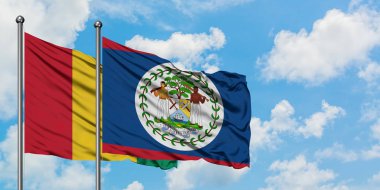Gine ve Belize bayrağı birlikte beyaz bulutlu mavi gökyüzüne karşı rüzgarda sallayarak. Diplomasi kavramı, uluslararası ilişkiler.