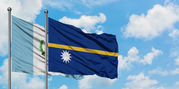 Bandera de Guatemala y Nauru ondeando en el viento contra el cielo azul nublado blanco juntos. Concepto diplomático, relaciones internacionales . — Foto de Stock
