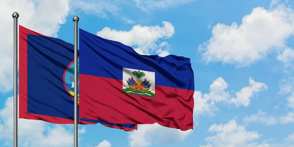 Guam ve Haiti bayrağı birlikte beyaz bulutlu mavi gökyüzüne karşı rüzgarda sallayarak. Diplomasi kavramı, uluslararası ilişkiler. — Stok fotoğraf