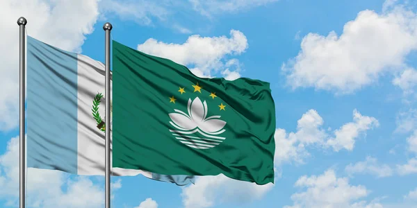 Bandera de Guatemala y Macao ondeando en el viento contra el cielo azul nublado blanco juntos. Concepto diplomático, relaciones internacionales . — Foto de Stock