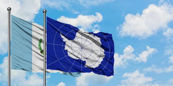 一緒に白い曇った青い空に対して風に振るグアテマラと南極の旗。外交概念、国際関係. — ストック写真