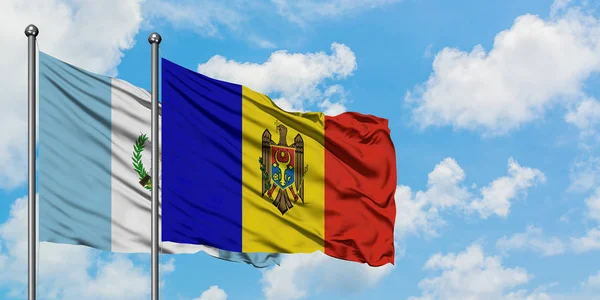 Guatemala és Moldova zászló integetett a szél ellen, fehér felhős kék eget együtt. Diplomáciai koncepció, nemzetközi kapcsolatok. — Stock Fotó