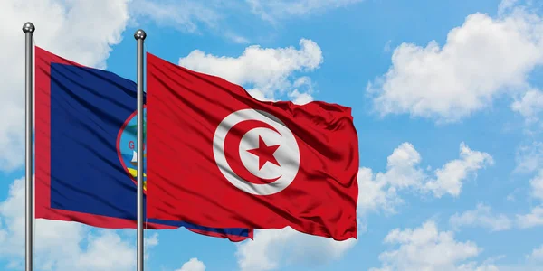 关岛和突尼斯国旗在风中飘扬，与白云蓝天相一起。外交概念、国际关系. — 图库照片