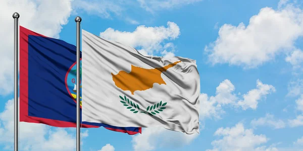 Guam ve Kıbrıs bayrağı birlikte beyaz bulutlu mavi gökyüzüne karşı rüzgarda sallayarak. Diplomasi kavramı, uluslararası ilişkiler. — Stok fotoğraf