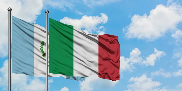 Guatemala en Italië vlag zwaaien in de wind tegen witte bewolkte blauwe hemel samen. Diplomatie concept, internationale betrekkingen. — Stockfoto