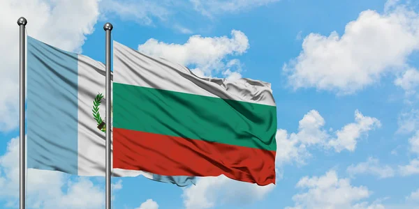 Bandera de Guatemala y Bulgaria ondeando en el viento contra el cielo azul nublado blanco juntos. Concepto diplomático, relaciones internacionales . — Foto de Stock