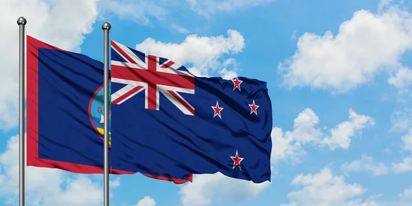 关岛和新西兰国旗在风中飘扬，与白云蓝天相一起。外交概念、国际关系. — 图库照片