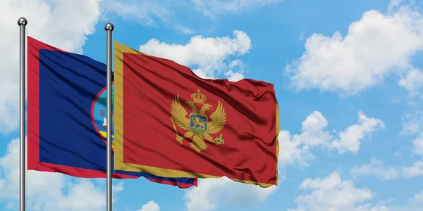 Guam and Montenegro flag waving in the wind against white cloudy blue sky together. Diplomacy concept, international relations. — Stock Photo, Image