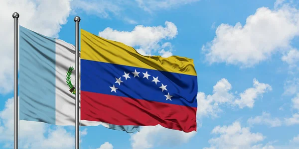 Гватемала і Венесуела прапор розмахуючи в вітру проти білого хмарного синього неба разом. Концепція дипломатії, міжнародні відносини. — стокове фото