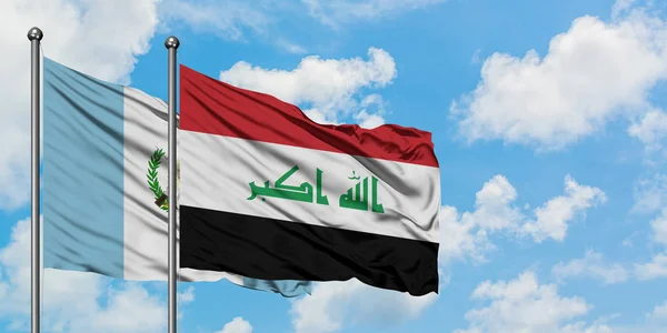 Guatemala and Iraq flag waving in the wind against white cloudy blue sky together. Diplomacy concept, international relations. — Stock Photo, Image