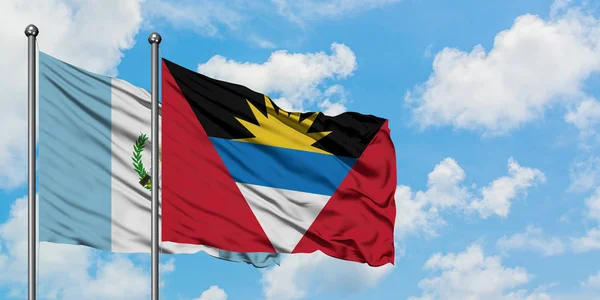 Guatemala ve Antigua ve Barbuda bayrağı birlikte beyaz bulutlu mavi gökyüzüne karşı rüzgarda sallayarak. Diplomasi kavramı, uluslararası ilişkiler. — Stok fotoğraf