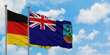 Almanya ve Montserrat bayrağı birlikte beyaz bulutlu mavi gökyüzüne karşı rüzgarda sallayarak. Diplomasi kavramı, uluslararası ilişkiler.