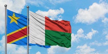 Kongo ve Madagaskar bayrağı birlikte beyaz bulutlu mavi gökyüzüne karşı rüzgarda sallayarak. Diplomasi kavramı, uluslararası ilişkiler.