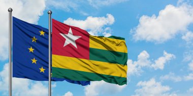 Avrupa Birliği ve Togo bayrağı birlikte beyaz bulutlu mavi gökyüzüne karşı rüzgarda sallayarak. Diplomasi kavramı, uluslararası ilişkiler.