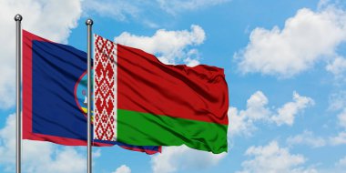 Guam ve Beyaz Rusya bayrağı birlikte beyaz bulutlu mavi gökyüzüne karşı rüzgarda sallayarak. Diplomasi kavramı, uluslararası ilişkiler.