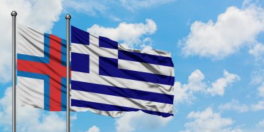 Faroe Adaları ve Yunanistan bayrağı birlikte beyaz bulutlu mavi gökyüzüne karşı rüzgarsal sallayarak. Diplomasi kavramı, uluslararası ilişkiler.