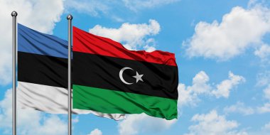 Estonya ve Libya bayrağı birlikte beyaz bulutlu mavi gökyüzüne karşı rüzgarsal sallayarak. Diplomasi kavramı, uluslararası ilişkiler.