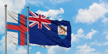 Faroe Adaları ve Anguilla bayrağı birlikte beyaz bulutlu mavi gökyüzüne karşı rüzgarda sallayarak. Diplomasi kavramı, uluslararası ilişkiler.