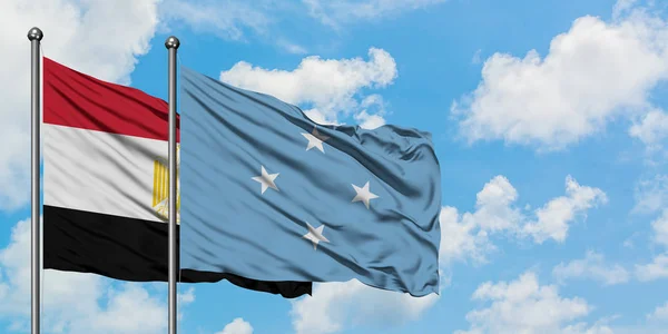 Egito e Micronésia bandeira acenando no vento contra o céu azul nublado branco juntos. Conceito de diplomacia, relações internacionais . — Fotografia de Stock