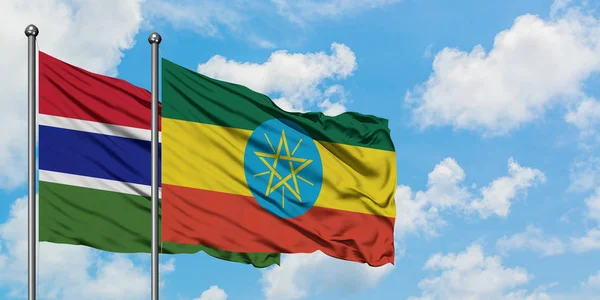Gambia and Ethiopia flag waving in the wind against white cloudy blue sky together. Diplomacy concept, international relations. — Stock Photo, Image