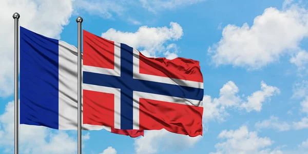 Bandera de Francia y Bouvet Islands ondeando en el viento contra el cielo azul nublado blanco juntos. Concepto diplomático, relaciones internacionales . — Foto de Stock