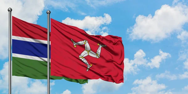 Gambiya ve Isle Of Man bayrağı birlikte beyaz bulutlu mavi gökyüzüne karşı rüzgarda sallayarak. Diplomasi kavramı, uluslararası ilişkiler. — Stok fotoğraf
