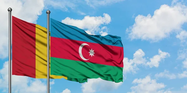 Bandera de Guinea y Azerbaiyán ondeando en el viento contra el cielo azul nublado blanco juntos. Concepto diplomático, relaciones internacionales . — Foto de Stock