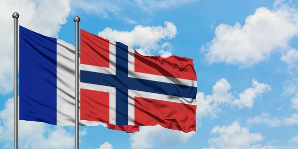 Bandera de Francia y Noruega ondeando en el viento contra el cielo azul nublado blanco juntos. Concepto diplomático, relaciones internacionales . — Foto de Stock