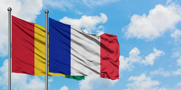 Bandera de Guinea y Francia ondeando en el viento contra el cielo azul nublado blanco juntos. Concepto diplomático, relaciones internacionales . — Foto de Stock