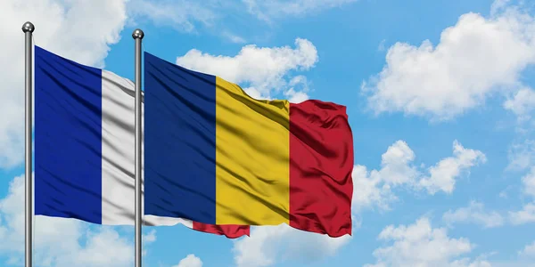 Francia e Romania bandiera sventolando nel vento contro bianco cielo blu nuvoloso insieme. Concetto di diplomazia, relazioni internazionali . — Foto Stock