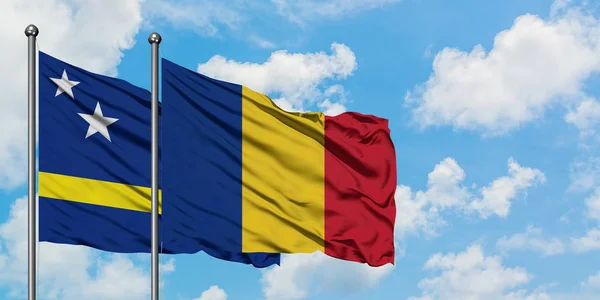 Bandera de Curazao y Rumania ondeando en el viento contra el cielo azul nublado blanco juntos. Concepto diplomático, relaciones internacionales . — Foto de Stock