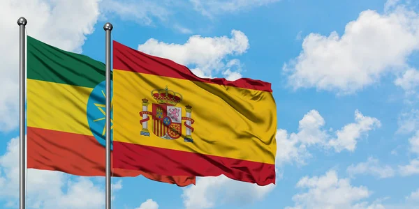 Etiopia e Spagna sventolano bandiera nel vento contro bianco cielo blu nuvoloso insieme. Concetto di diplomazia, relazioni internazionali . — Foto Stock