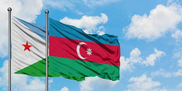 Bandera de Yibuti y Azerbaiyán ondeando en el viento contra el cielo azul nublado blanco juntos. Concepto diplomático, relaciones internacionales . — Foto de Stock