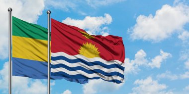 Gabon ve Kiribati bayrağı birlikte beyaz bulutlu mavi gökyüzüne karşı rüzgarda sallayarak. Diplomasi kavramı, uluslararası ilişkiler.