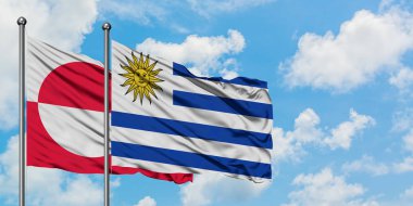 Grönland ve Uruguay bayrağı birlikte beyaz bulutlu mavi gökyüzüne karşı rüzgarsal sallayarak. Diplomasi kavramı, uluslararası ilişkiler.