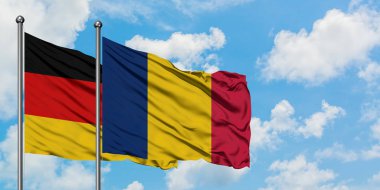 Almanya ve Çad bayrağı birlikte beyaz bulutlu mavi gökyüzüne karşı rüzgarda sallayarak. Diplomasi kavramı, uluslararası ilişkiler.